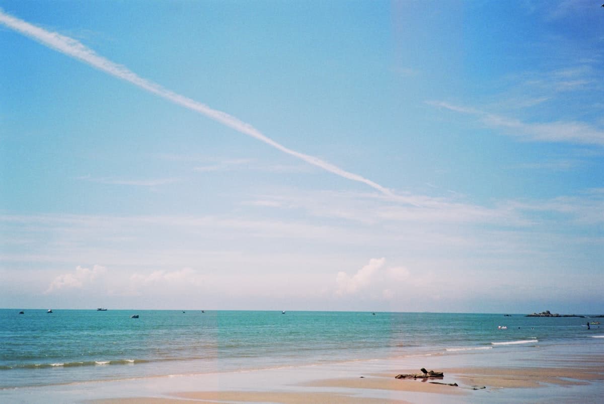 Солнечный тропический пляж с пальмами и спокойным бирюзовым морем в сухой сезон