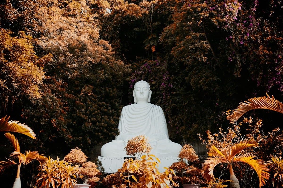 Белая статуя Будды среди тропической зелени на Мраморных горах в Дананге