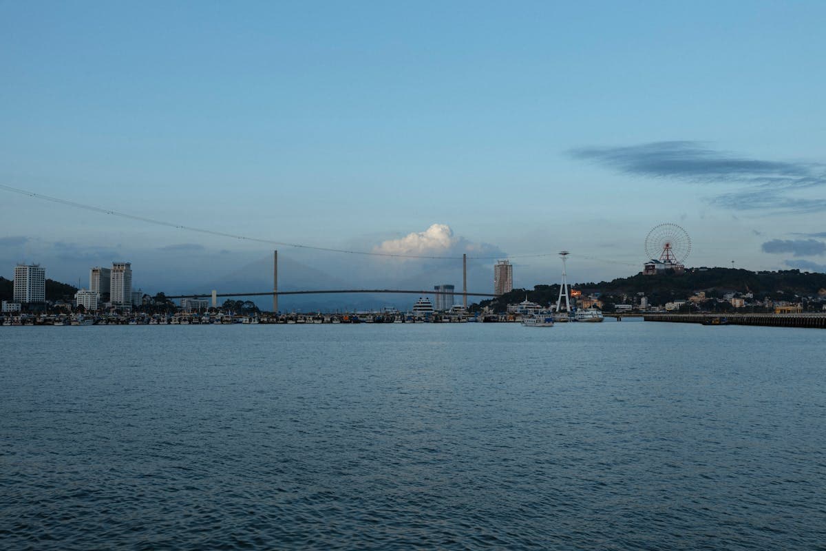 Пляж Бай Чай в городе Халонг с набережной и мостом на фоне