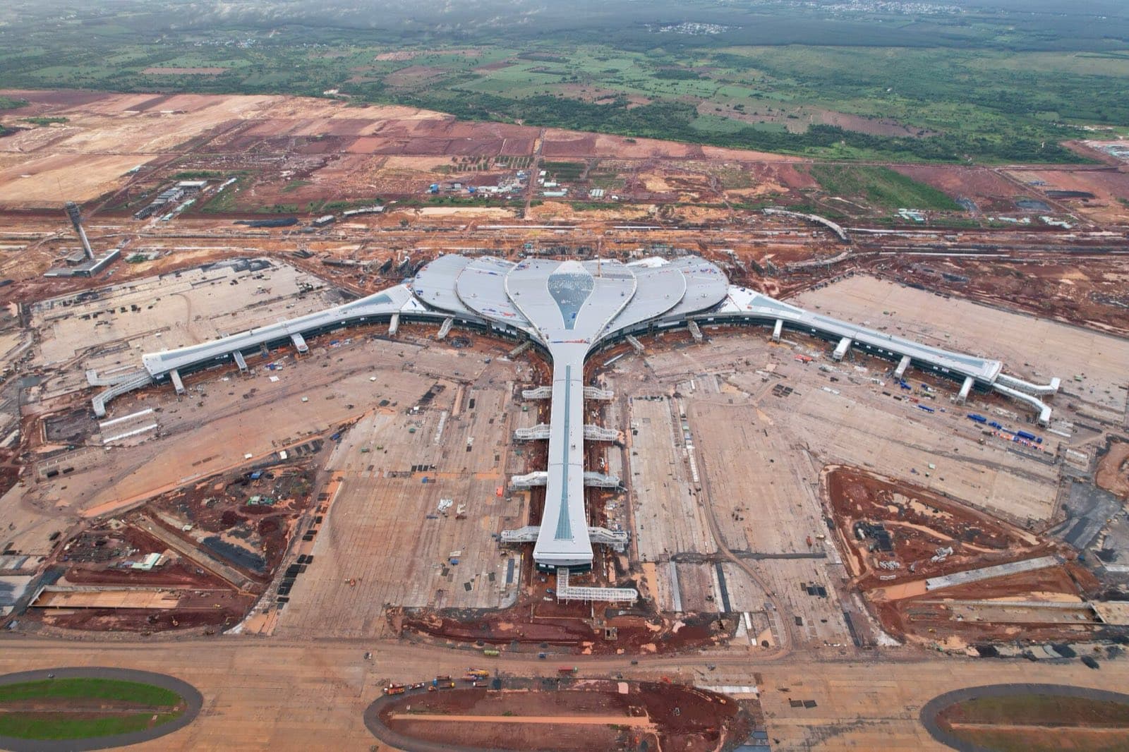 Aerial view of the Long Thanh terminal: central hall, two wings and a pier amid construction