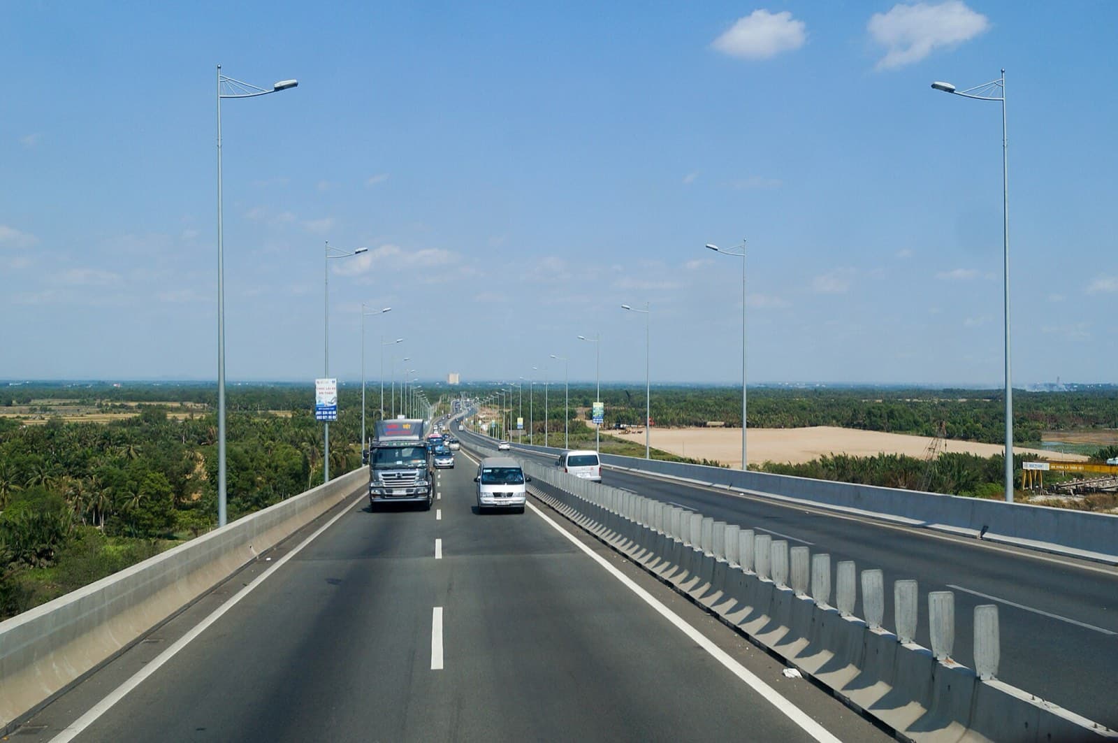 Long Thanh bridge on the HCMC–Long Thanh–Dau Giay expressway, a truck and minivans in the lanes