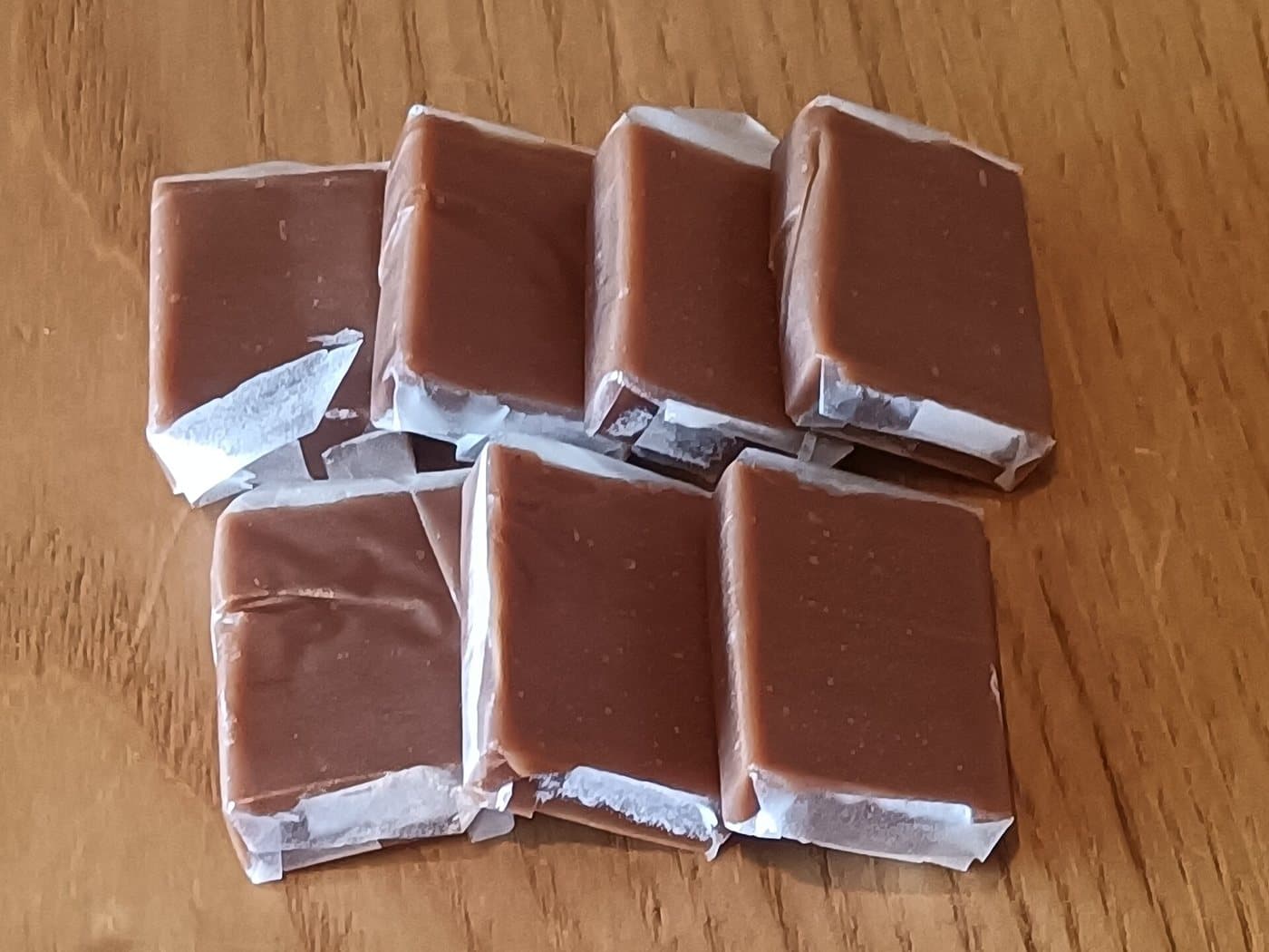 Кокосовые конфеты kẹo dừa из Бенче с какао в обёртке из рисовой бумаги на столе