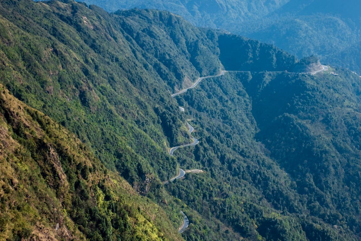 Горный серпантин с извилистой дорогой среди зелёных тропических гор Вьетнама
