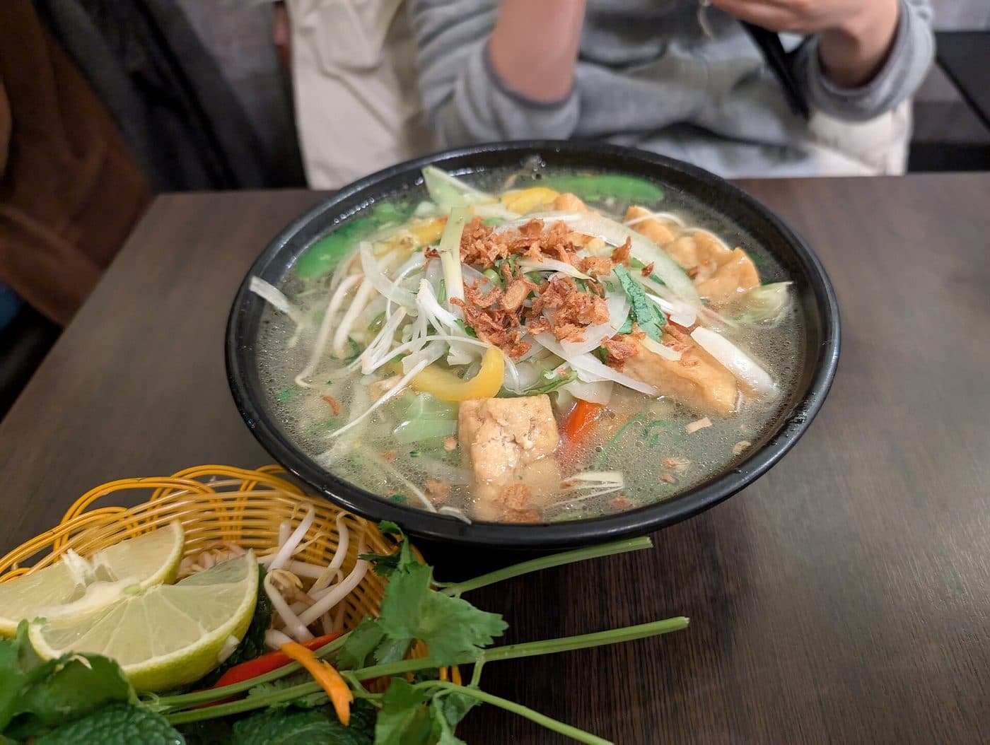 Веганский phở chay с тофу, овощами и тарелкой зелени