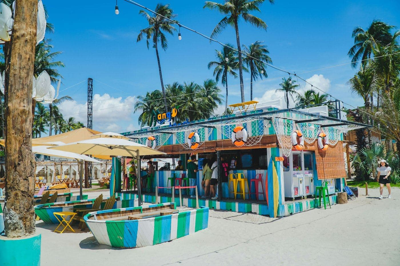 Beach bar with bright stools and palm trees in Phan Thiet