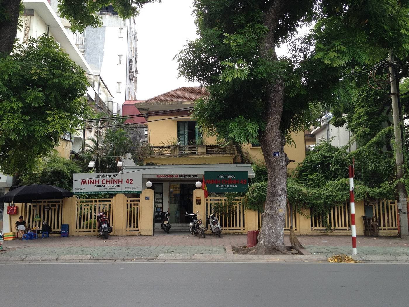 The Minh Chính 42 pharmacy behind a yellow fence on Quang Trung Street in Hanoi