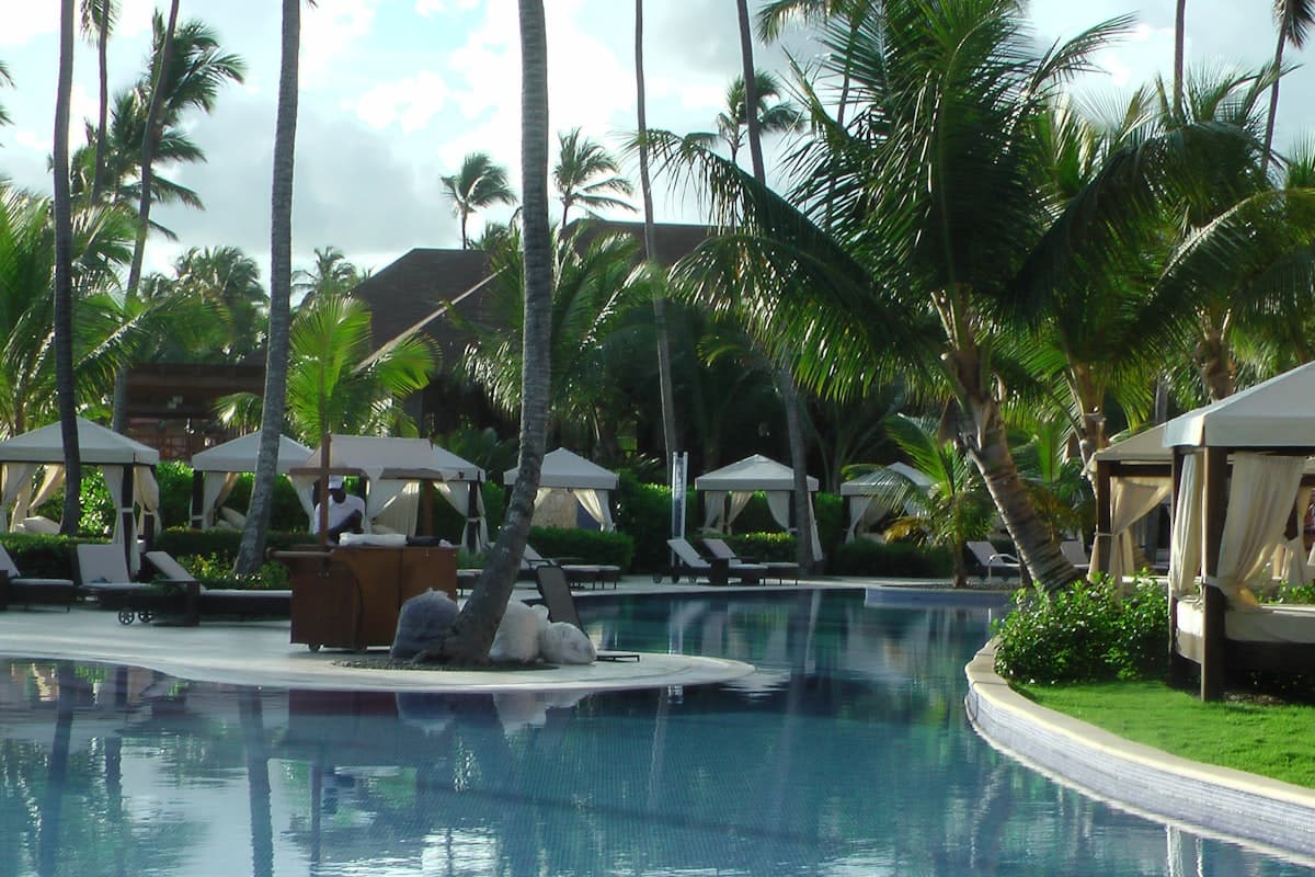 Бассейн-инфинити в тропическом отеле Вьетнама с пальмами и шезлонгами