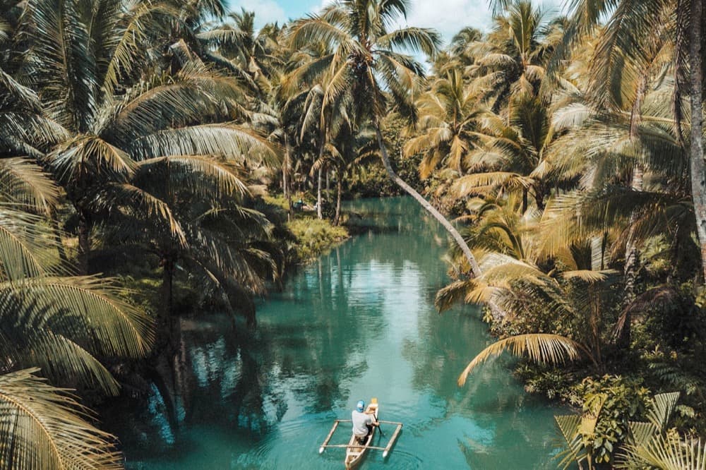 Тропическая река с пальмами и лодкой — экскурсия по Вьетнаму в январе