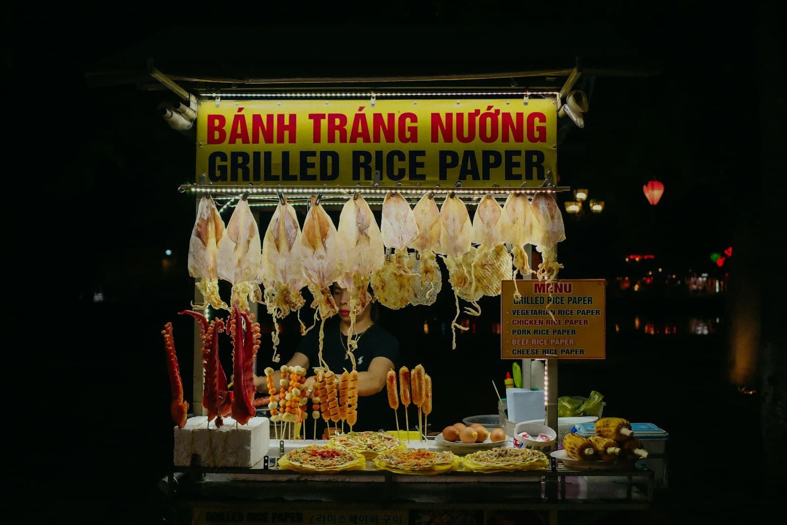 Уличный лоток бань транг ныонг с вывеской Grilled Rice Paper и заготовками на прилавке