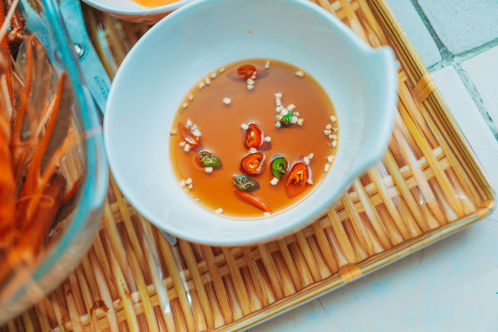 Соус ныок чам с рубленым чесноком и кольцами красного и зелёного чили в пиале