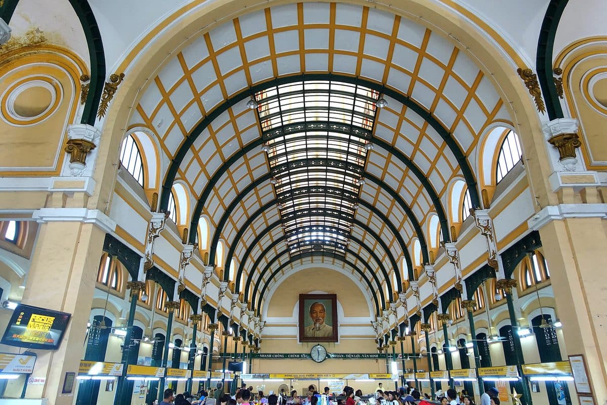 Main hall of Saigon Central Post Office with Vietnam Post counters where parcels are packed and sent