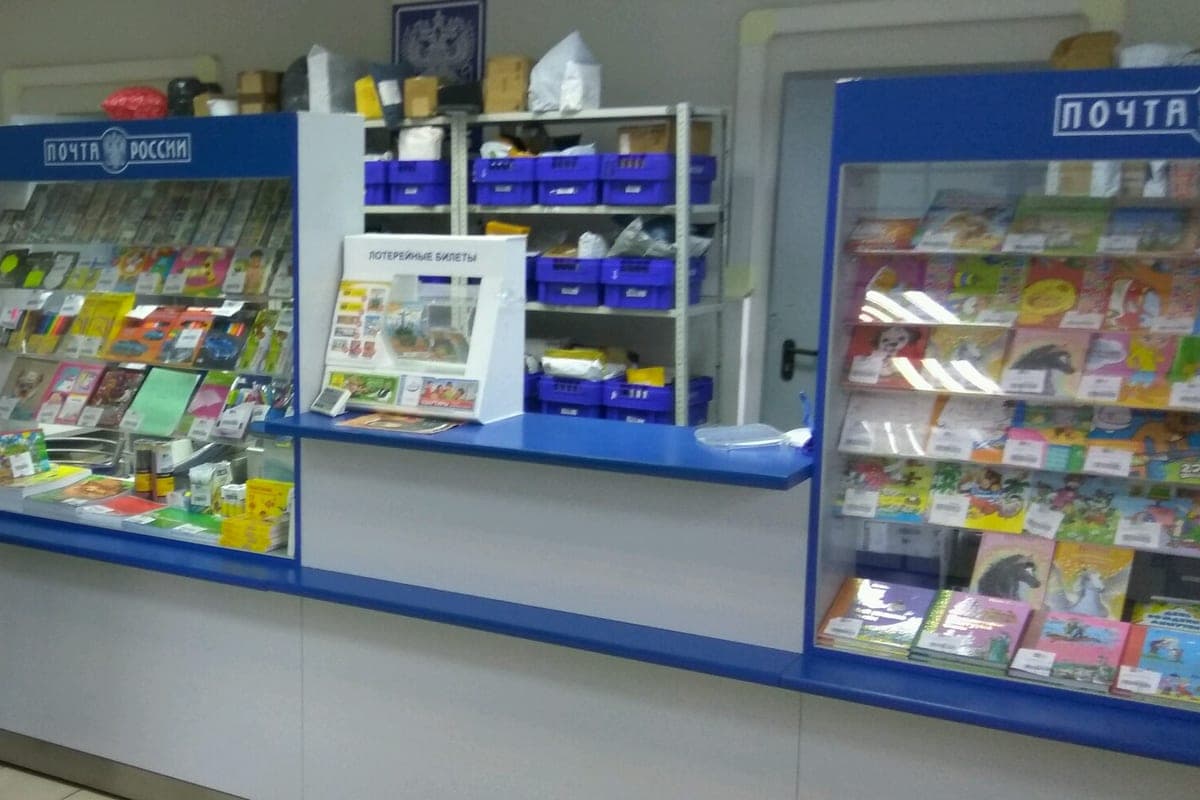 Customer hall of a Russian Post branch in Moscow: counter, display cases and shelves of parcels