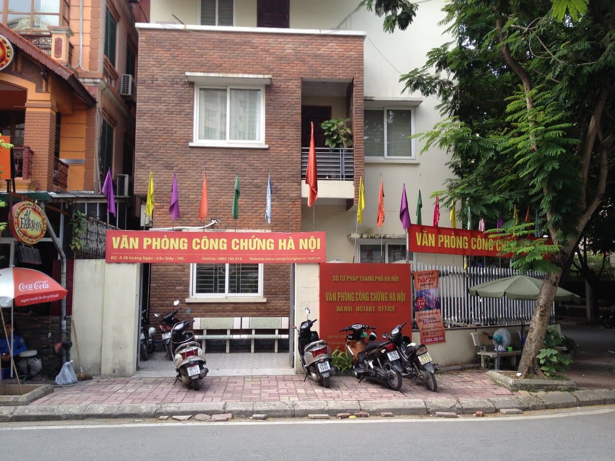 Sign of a Hanoi notary office on Hoang Ngan street with motorbikes parked outside