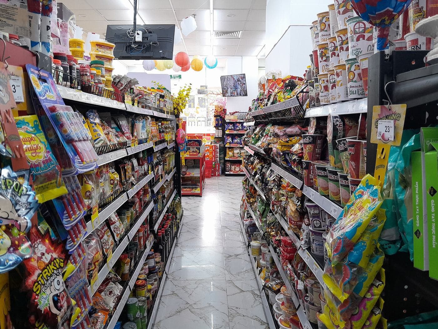 Ряд магазина WinMart+ в Ханое: снеки, соусы и лапша с ценниками в донгах