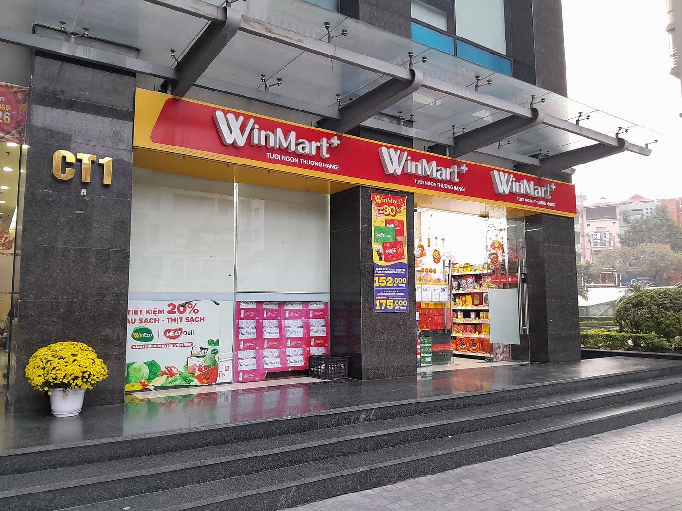Вывеска магазина WinMart+ на первом этаже жилого дома в Ханое