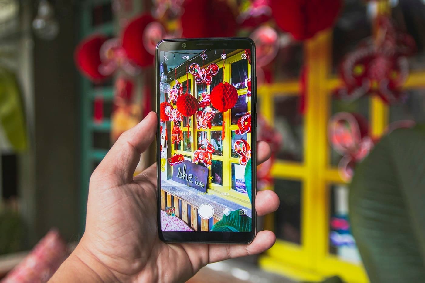 Smartphone held up in a Ho Chi Minh City cafe decorated with lanterns for the Mid-Autumn Festival