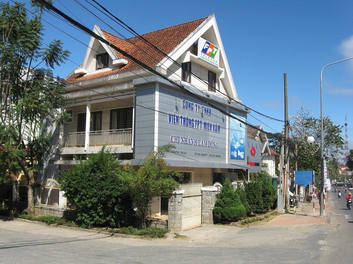 FPT Telecom office in Da Lat: tiled-roof house with the FPT logo and cables over the street