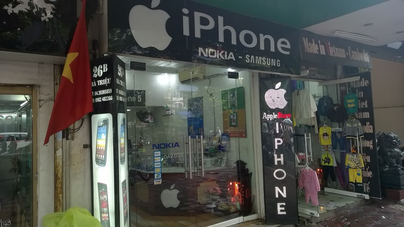 Mobile phone shop on Bà Triệu street in Hanoi with a Vietnamese flag and phone numbers on the sign