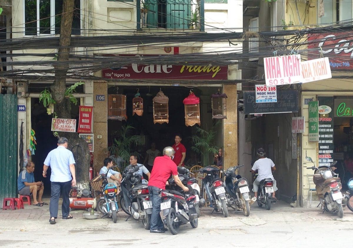 Ngọc Hà street in Hanoi with cafes, scooters and a top-up card sign for Vina, Mobi and Viettel