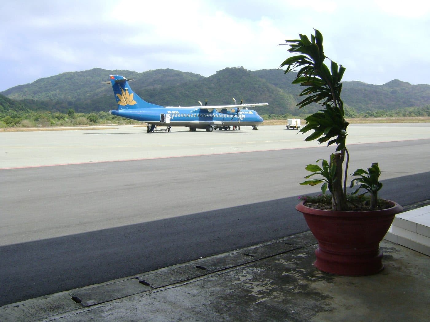 Самолёт ATR-72 Vietnam Airlines на перроне аэропорта Кондао на фоне зелёных гор
