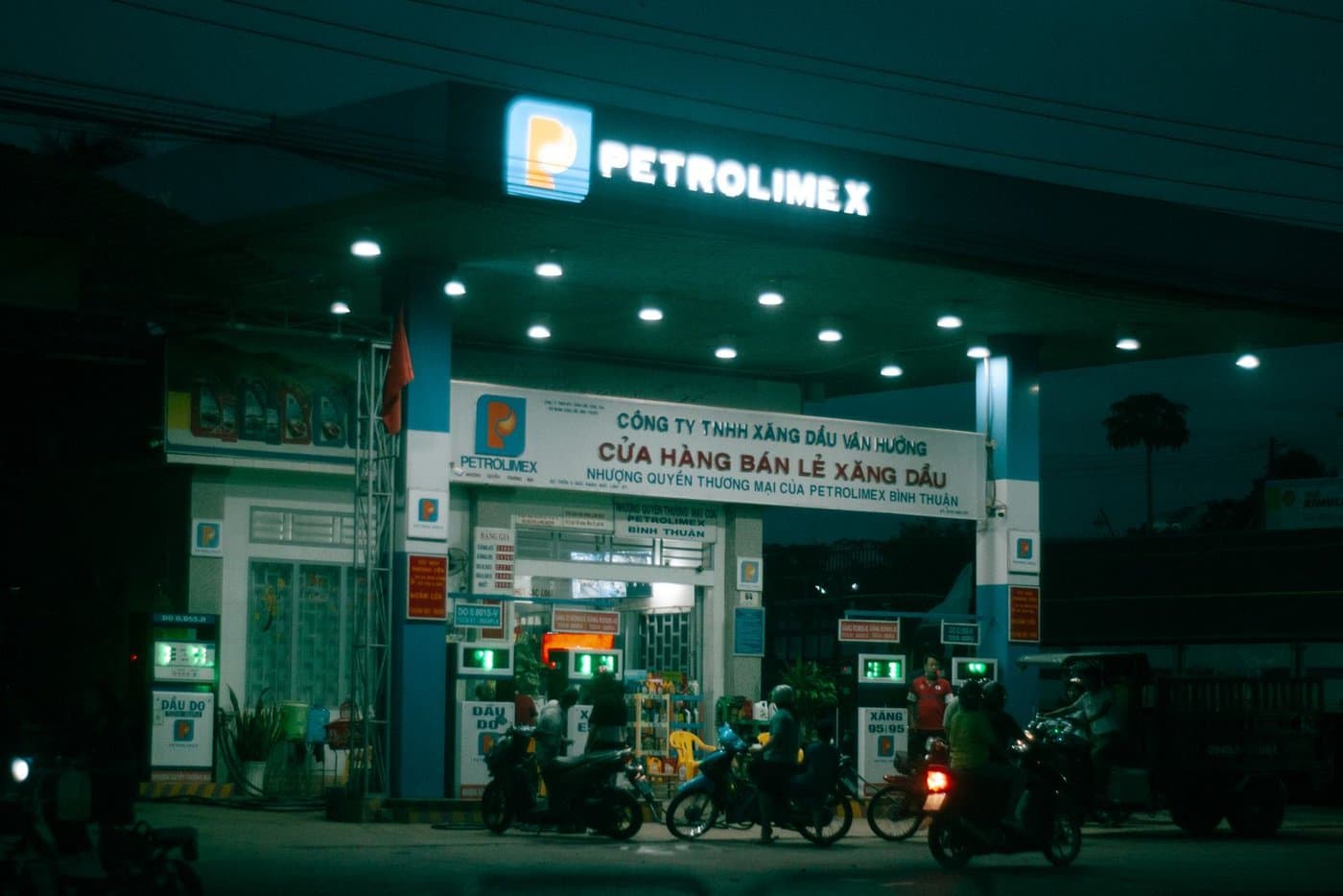 Вьетнамская заправка Petrolimex вечером, мотобайки у колонок