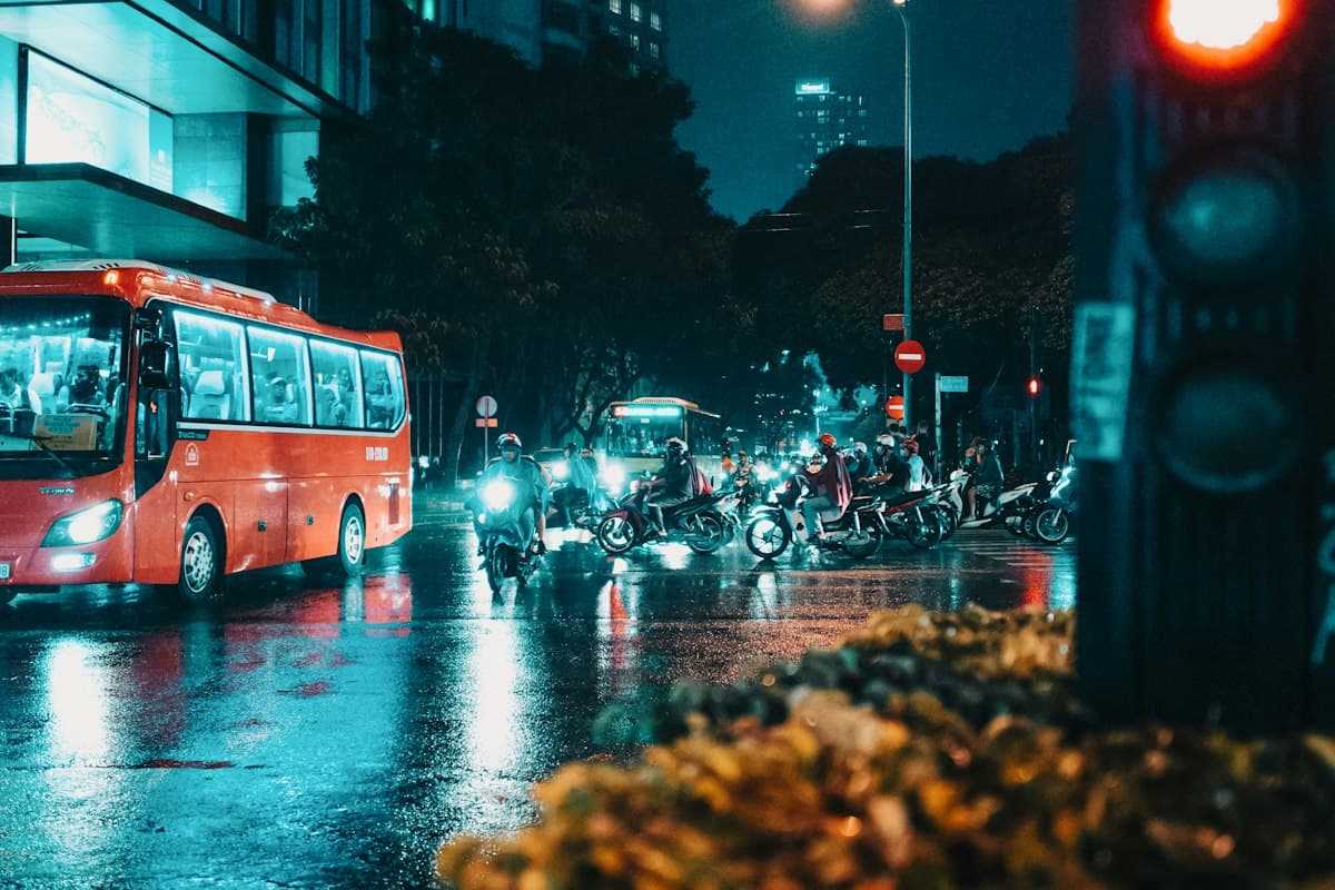 Wet road and a stream of scooters riding through rain in Vietnam