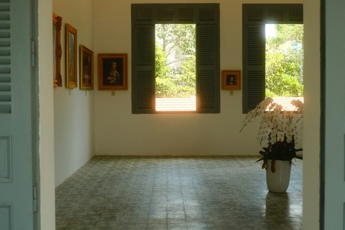 Empty room with green shutters and patterned tile floor in a Vietnamese house