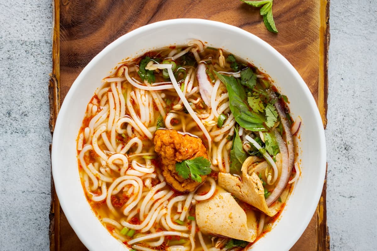 Стол с вьетнамскими блюдами в ресторане Дананга — ми куанг, бань сео и морепродукты