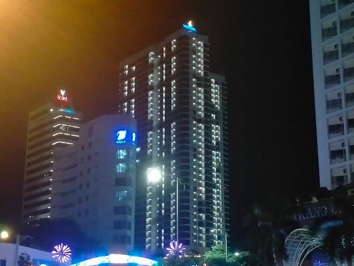 Vinpearl Condotel Empire tower in Nha Trang at night with the lit Vinpearl sign on the roof