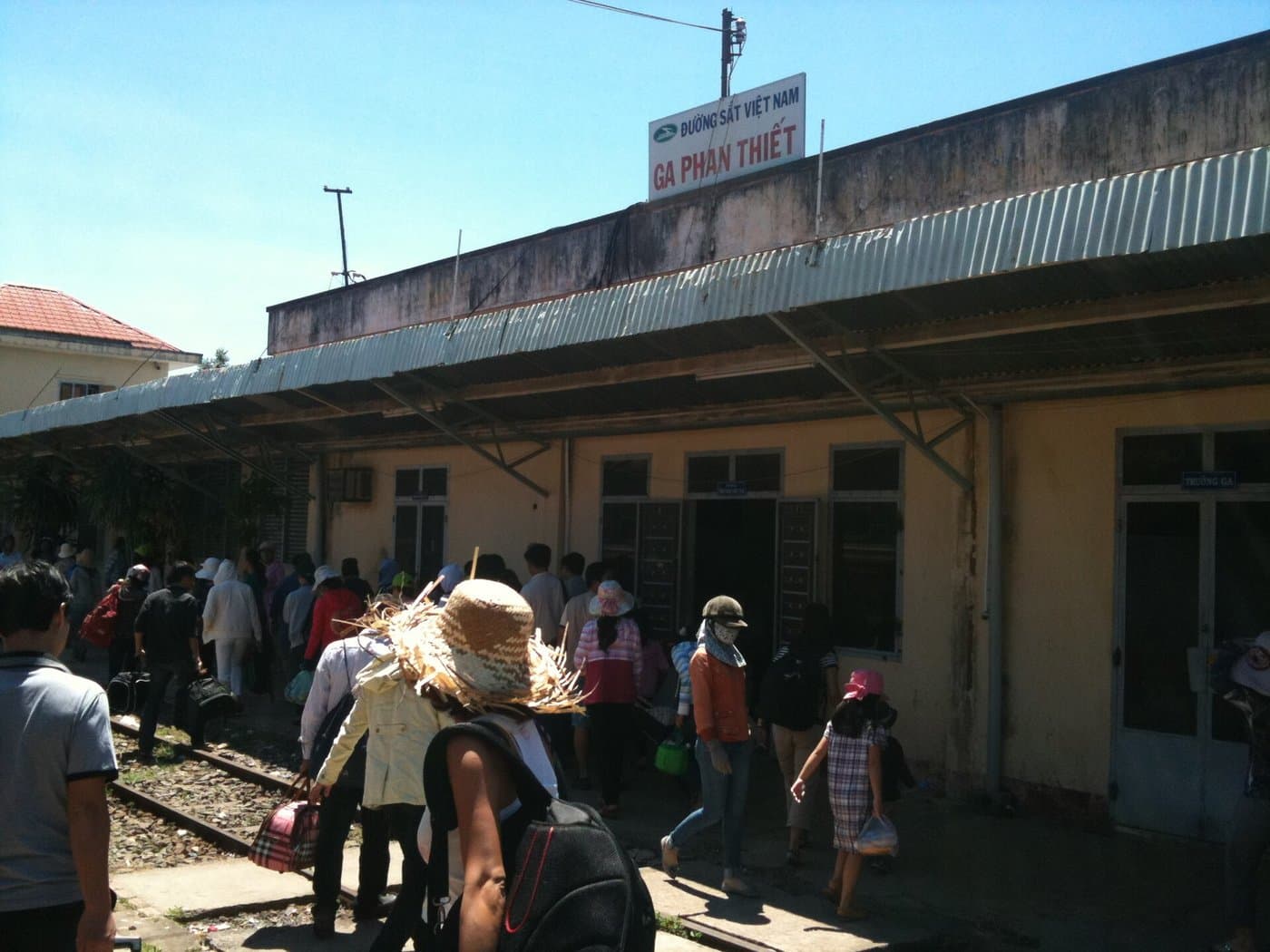 Станция Ga Phan Thiet с вывеской Вьетнамских железных дорог и пассажирами на перроне