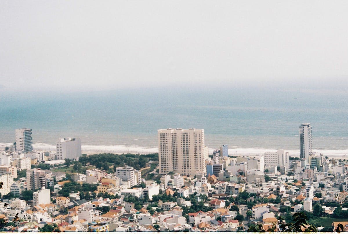 Вьетнамский приморский город с высоты — высотки, жилые кварталы и море на горизонте