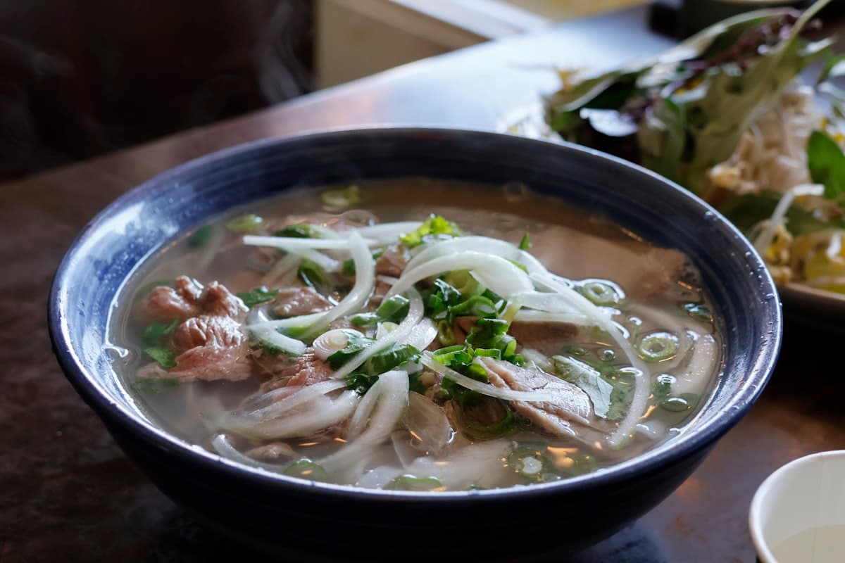 Тарелка фо бо с зеленью и лаймом в нячангском кафе