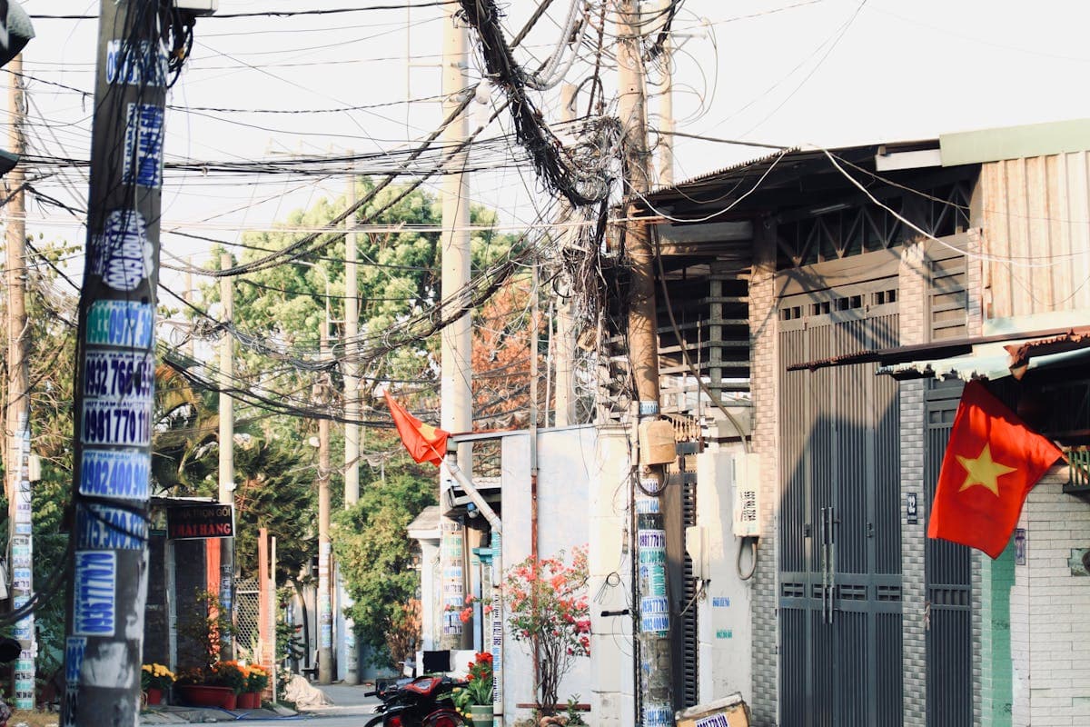 Вьетнамская улица с мотоциклами и вывесками на фоне жилых домов