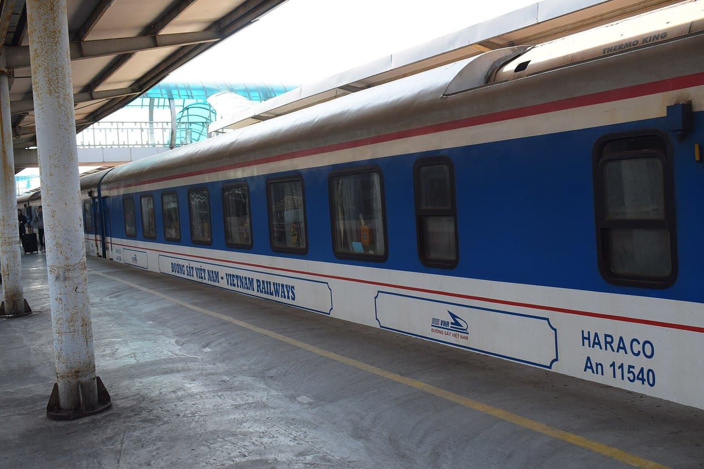 Синий вагон Vietnam Railways у платформы с жёлтой линией безопасности
