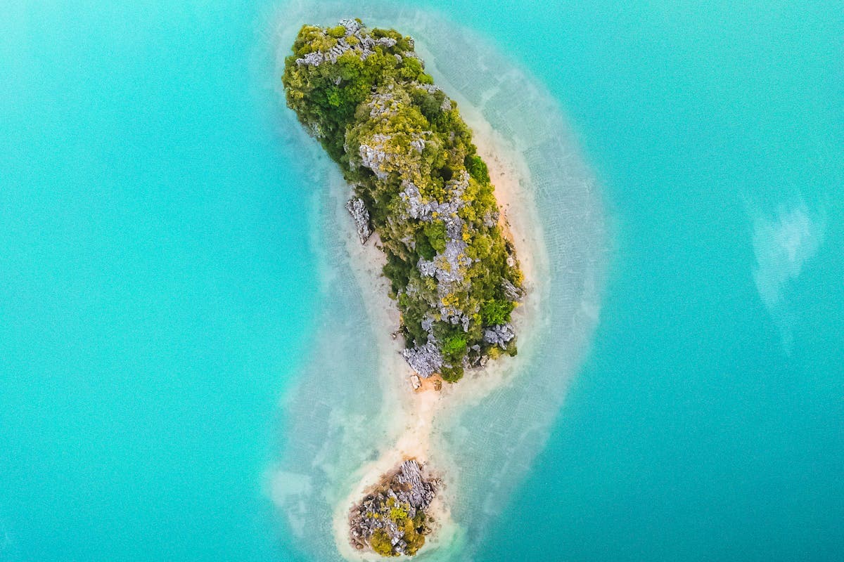 Зелёный тропический остров в бирюзовом море — вид сверху