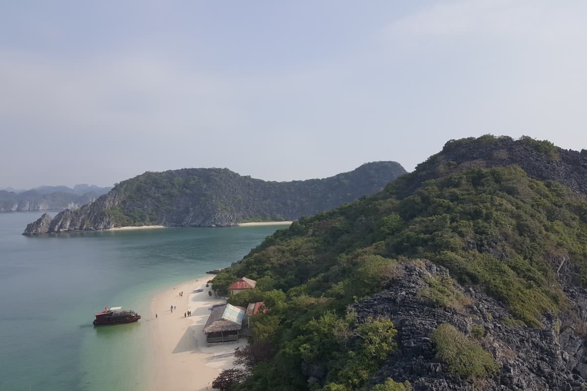 Белый песчаный пляж среди зелёных гор Вьетнама — бухта с бирюзовой водой