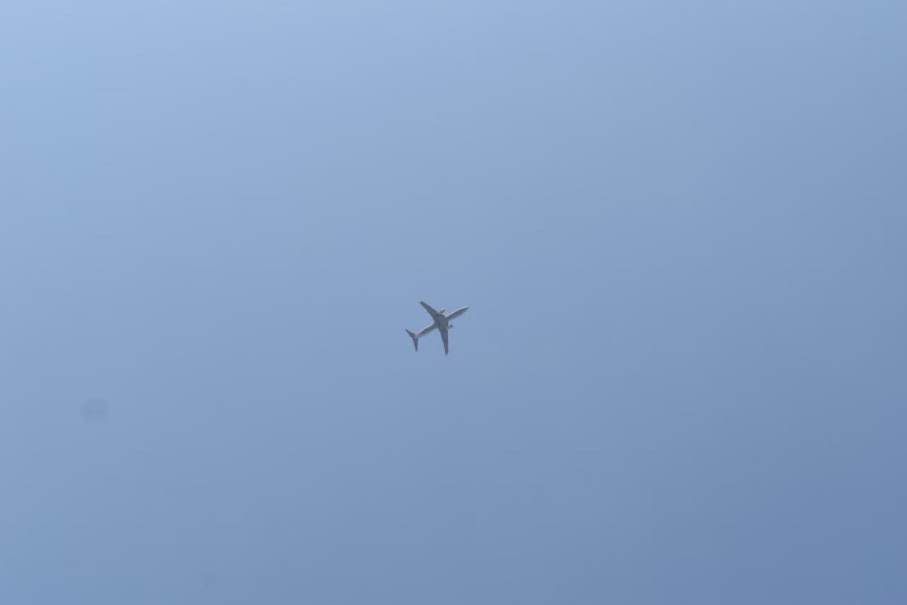 Пассажирский самолёт в полёте на фоне облаков и голубого неба