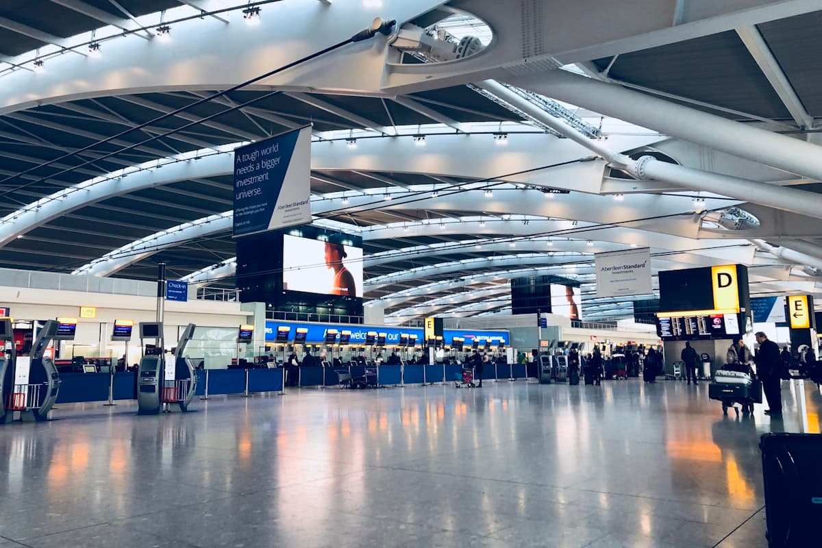 Самолёт заходит на посадку на взлётную полосу аэропорта с горами на горизонте