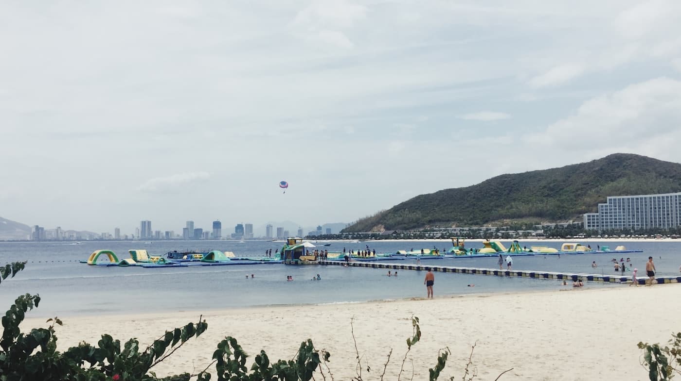 Городской пляж Нячанга с небоскрёбами на фоне голубого моря