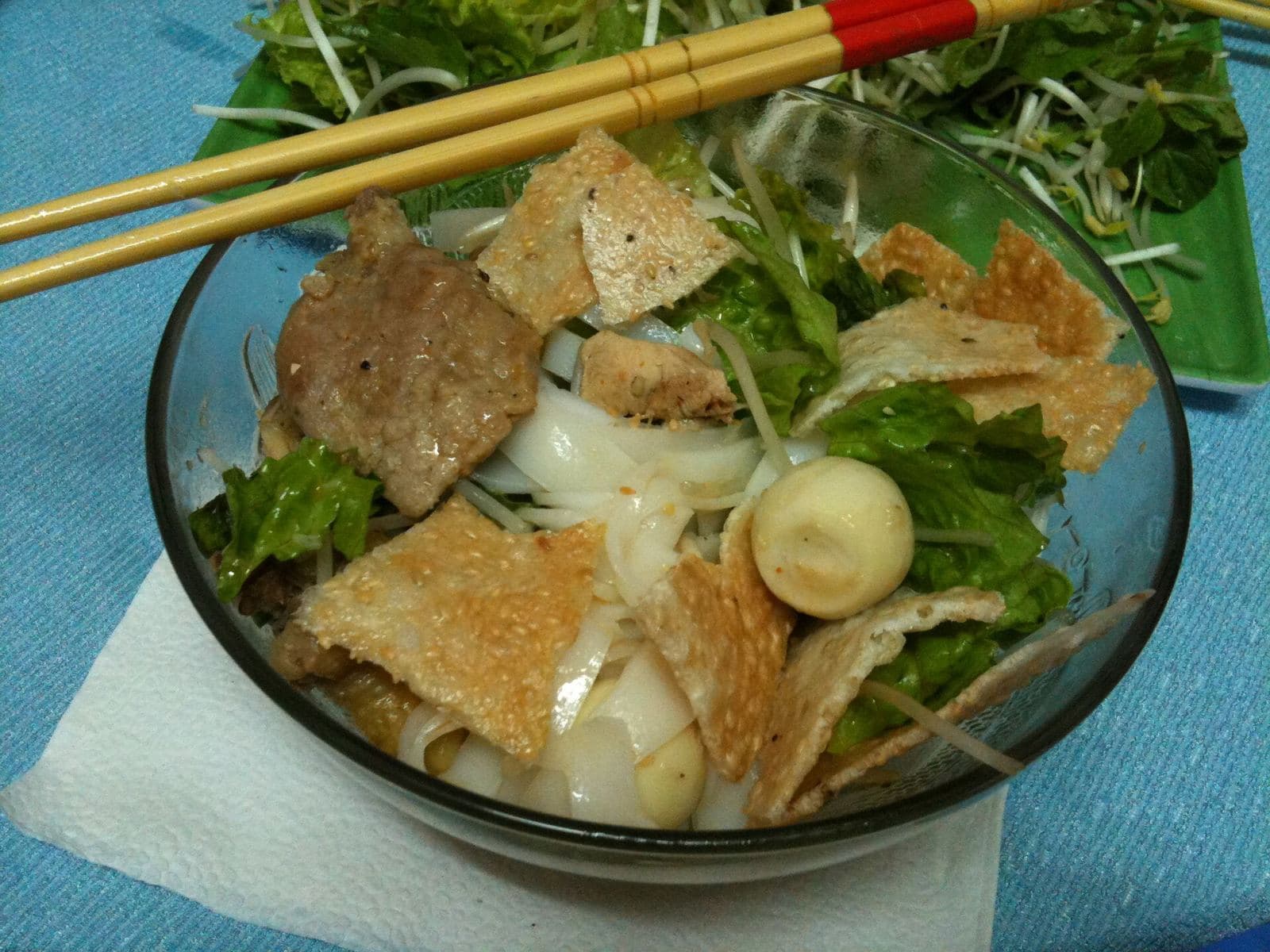 Миска ми куанг с раскрошенным кунжутным крекером, говядиной, перепелиным яйцом и палочками на краю