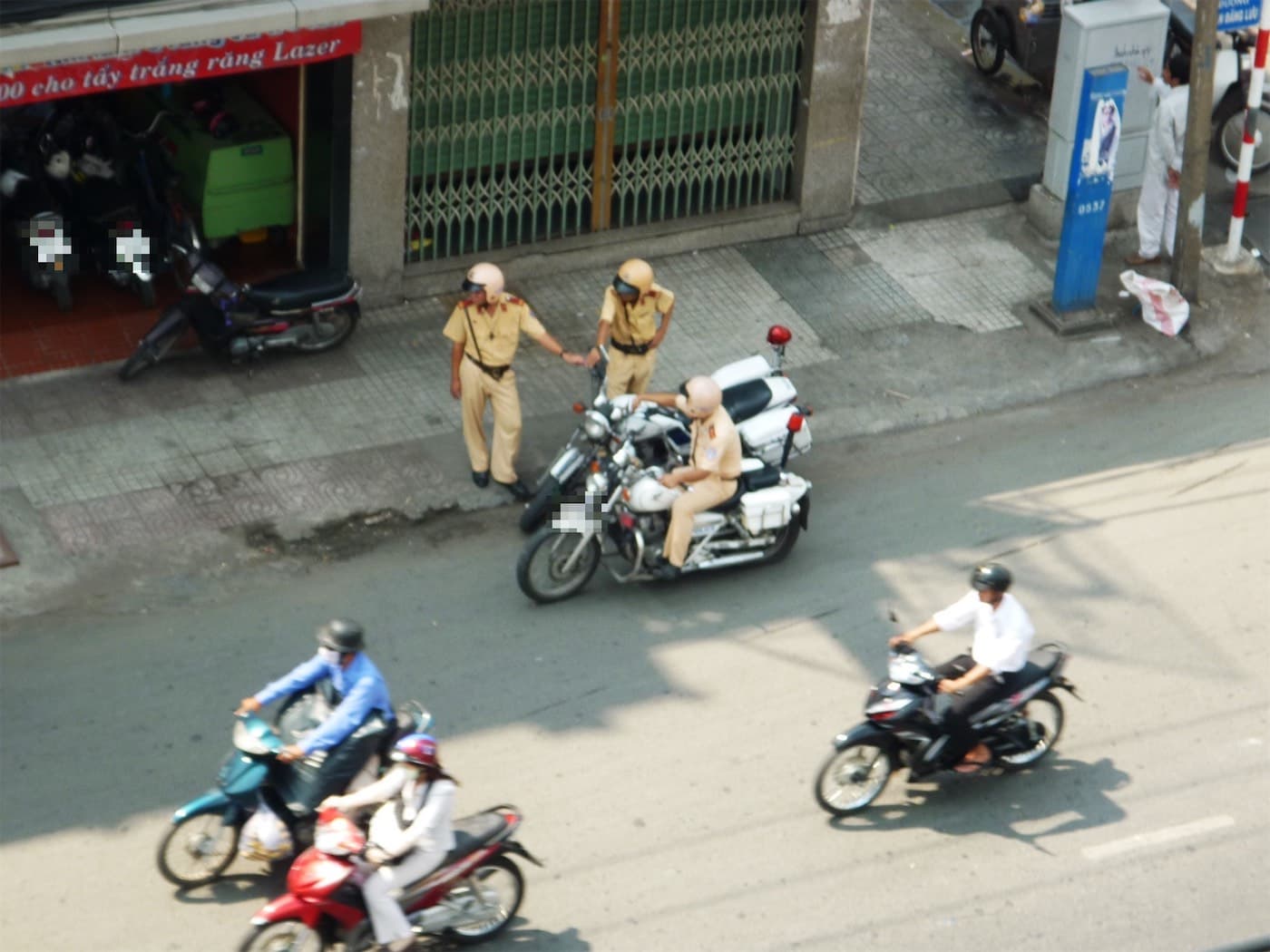 Vietnamese traffic police officers with motorcycles at the roadside, seen from above