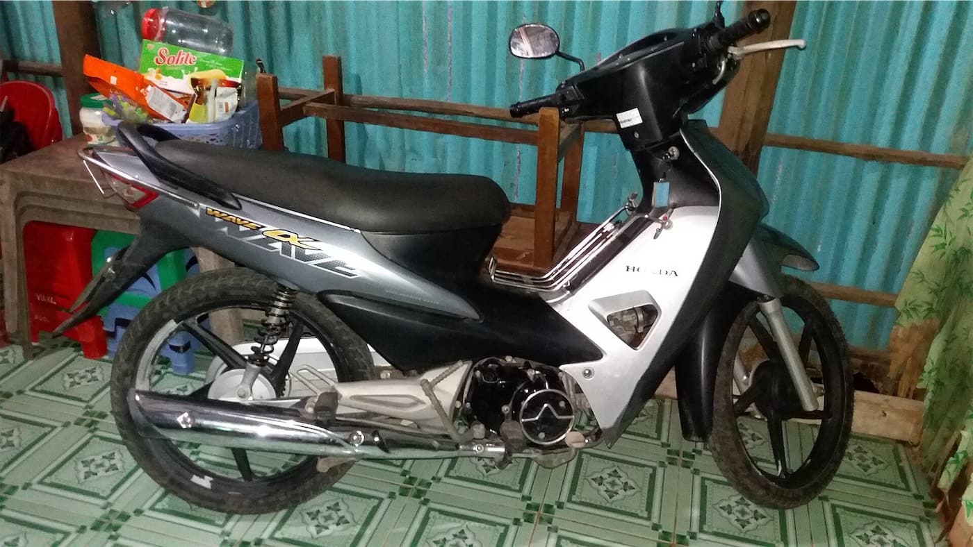 Used grey Honda Wave Alpha motorbike parked inside a home in Vietnam