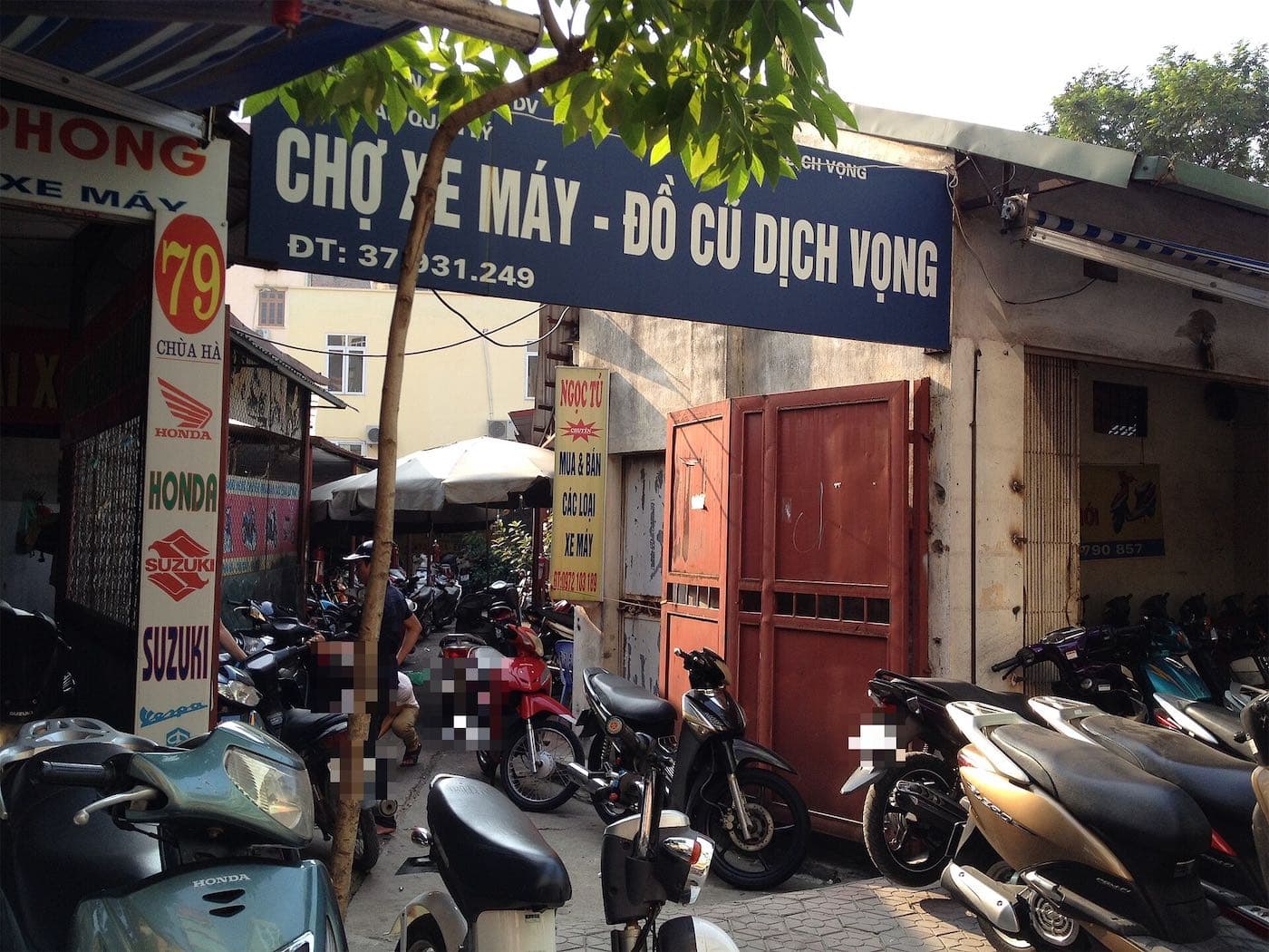 Entrance to the Dịch Vọng used motorbike market in Hanoi with bikes by the gate
