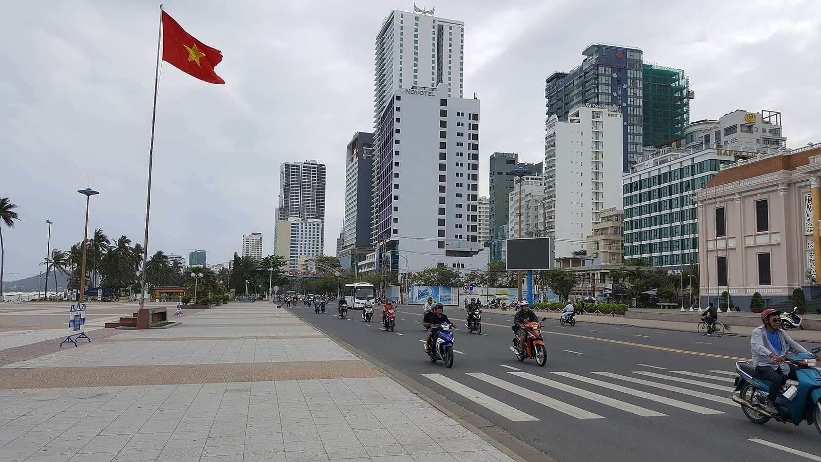 The Tran Phu beachfront in Nha Trang with motorbike traffic, palms and coastal high rises