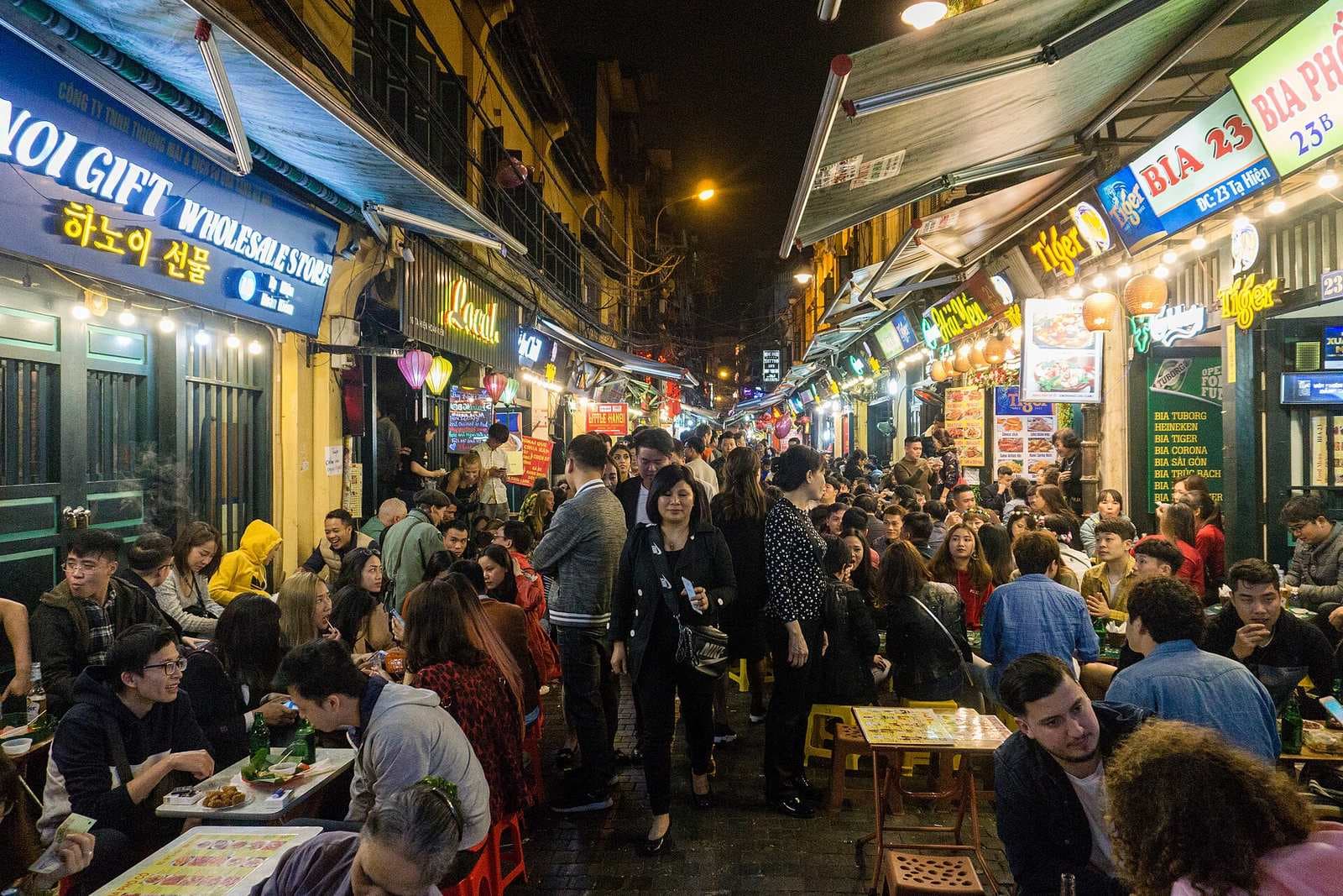 Ta Hien beer street in the Hanoi Old Quarter at night, neon and pavement tables