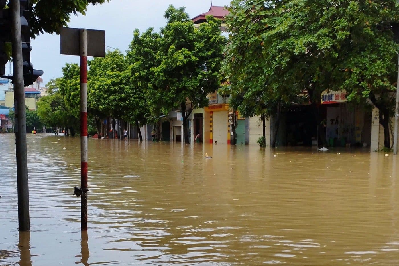 Flooded street with shuttered shops near a market in Thai Nguyen during a flood